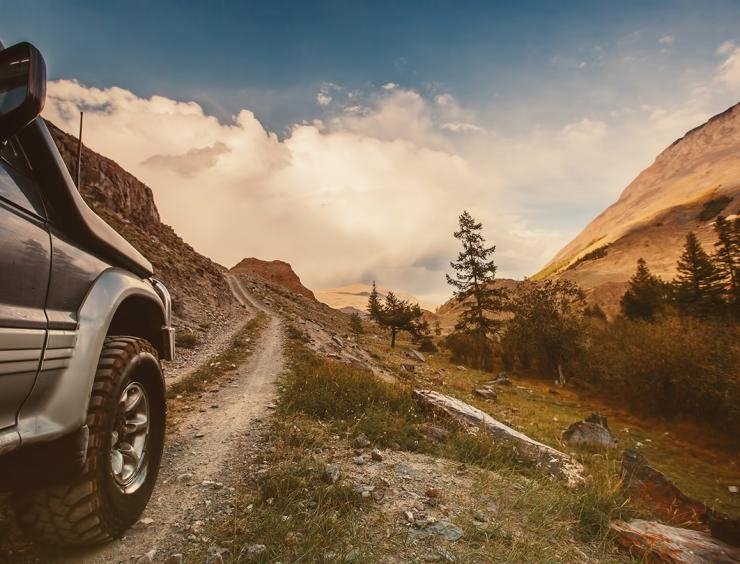 um camião a percorrer uma estrada de terra batida nas montanhas